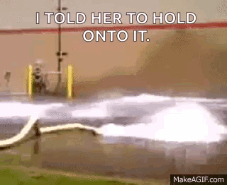 A Gif Of A Hose Spraying Water With The Words I Told Her To Hold Onto It . GIF