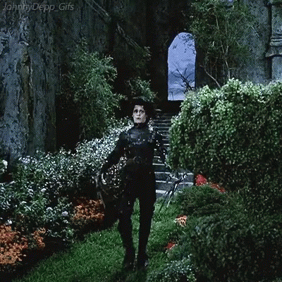 A Gif Of Johnny Depp Standing In A Garden GIF