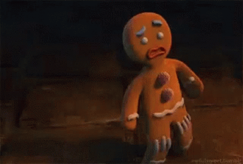 A Gingerbread Man From Shrek Is Standing On A Wooden Floor . GIF