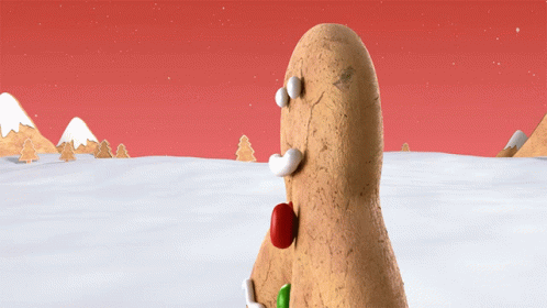 A Gingerbread Man Standing In The Snow With A Red Nose GIF
