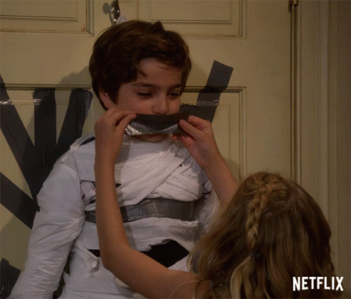 A Girl Covering A Boy 'S Mouth With Duct Tape With A Netflix Logo In The Bottom Right Corner GIF