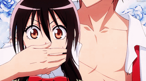 A Girl Covering Her Mouth With Her Hand While A Man Looks At Her GIF