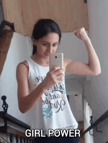 A Girl Flexes Her Muscles While Taking A Picture Of Herself With The Words Girl Power Below Her GIF