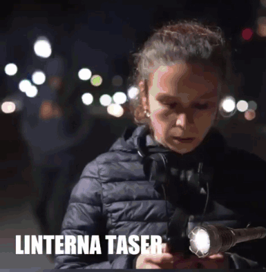 A Girl Holding A Flashlight With The Word Lanterna Taser Written Below Her GIF