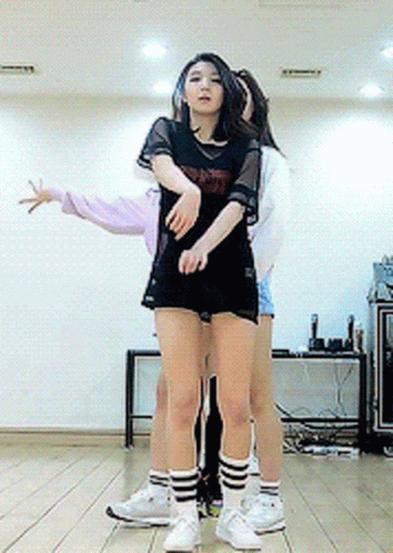 A Girl In A Black Shirt That Says ' Nct ' On It Is Hugging Another Girl GIF