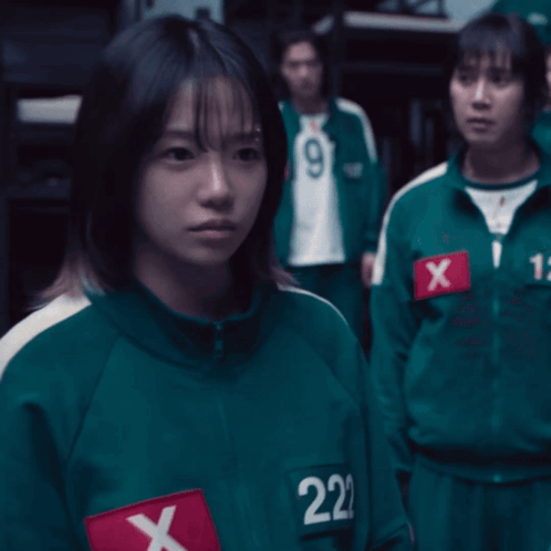 A Girl In A Green Uniform With The Number 222 On Her Chest GIF
