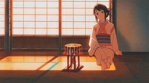 A Girl In A Kimono Sits On The Floor With A Drum In Front Of Her GIF