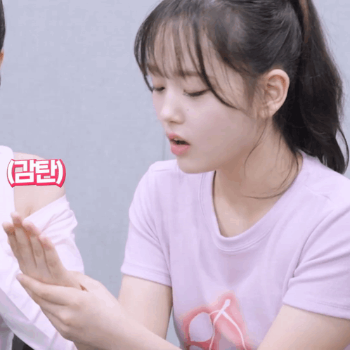 A Girl In A Pink Shirt Has A Sticker On Her Arm That Says ' Aee ' GIF
