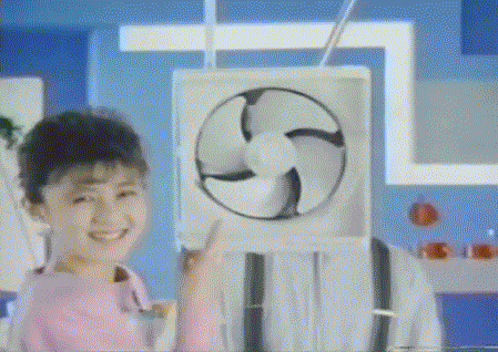 A Girl In A Pink Shirt Is Holding A Fan In Front Of Her Face . GIF