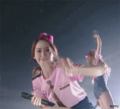 A Girl In A Pink Shirt Is Holding A Microphone And The Word Sunny Is On The Bottom GIF