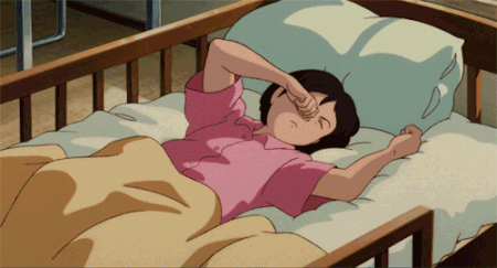 A Girl In A Pink Shirt Is Laying In A Bed And Rubbing Her Eyes GIF