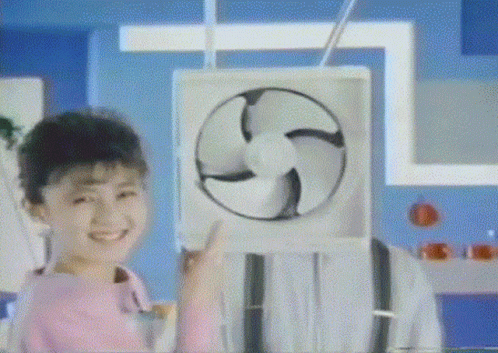 A Girl In A Pink Shirt Is Smiling And Holding A Fan GIF