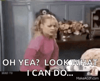 A Girl In A Pink Shirt Is Standing In A Kitchen And Saying `` Oh Yea ? Look What I Can Do . '' GIF