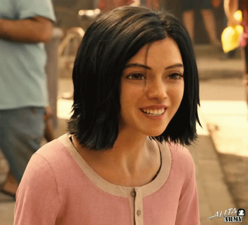 A Girl In A Pink Shirt With The Word Alita Written On The Bottom GIF