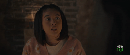 A Girl In A Pink Sweater Is Smiling In A Project Exit Advertisement GIF