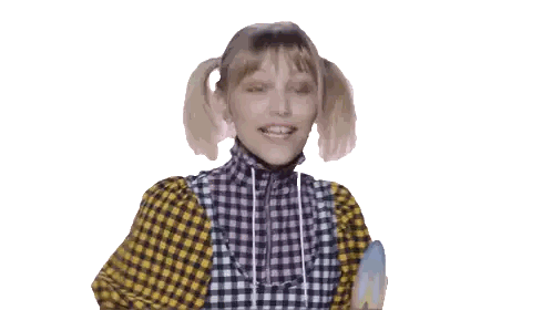 a girl in a plaid shirt and overalls is smiling