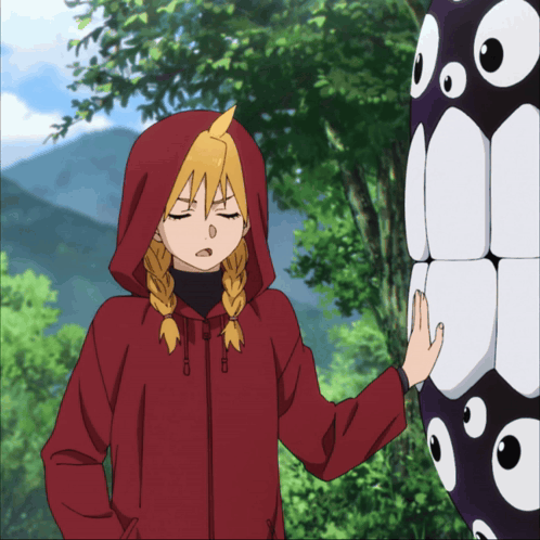 a girl in a red hooded jacket is touching a black object