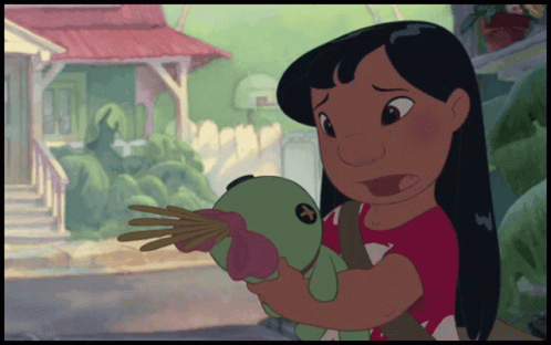a girl in a red shirt is holding a stuffed animal