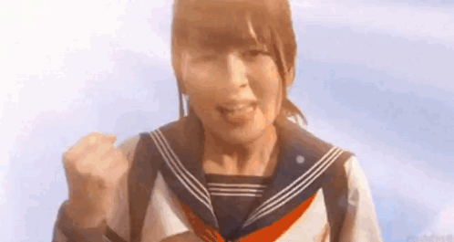 A Girl In A Sailor Uniform Is Making A Fist In The Air . GIF