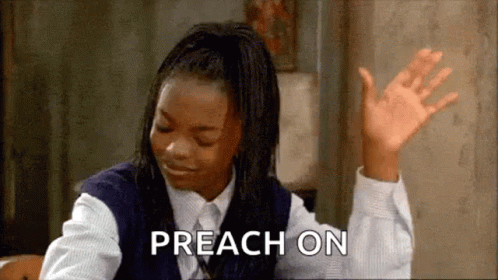 A Girl In A School Uniform Is Sitting At A Table With Her Hands In The Air And The Words Preach On Written Next To Her . GIF