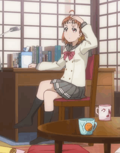 A Girl In A School Uniform Sits In A Chair With Her Hand On Her Head GIF