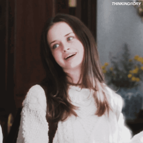 A Girl In A White Sweater Is Smiling With The Words Thinkingrory Behind Her GIF