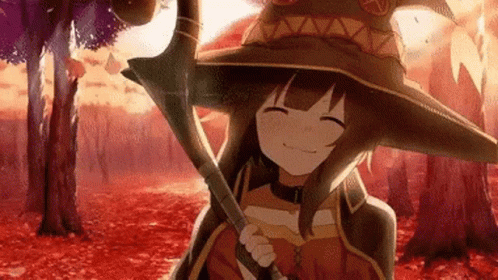 A Girl In A Witch Hat Is Holding A Cane In A Forest . GIF