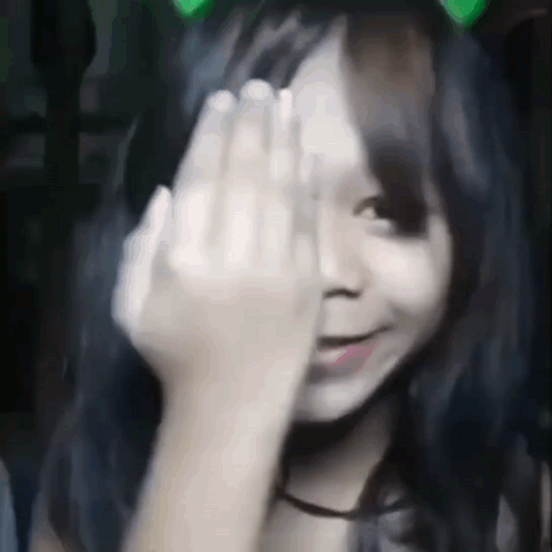 A Girl Is Covering Her Face With Her Hand . GIF