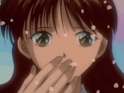 A Girl Is Covering Her Mouth With Her Hand And Petals Are Falling From Her Hair GIF