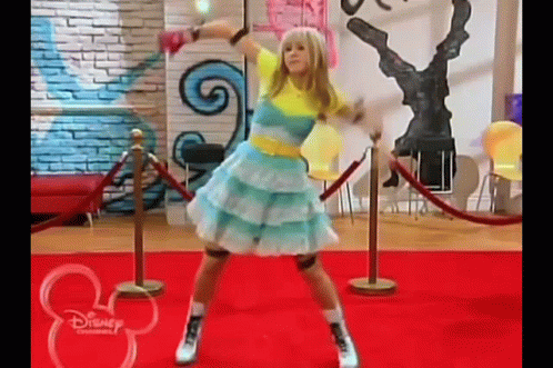 A Girl Is Dancing On A Red Carpet In A Room . GIF
