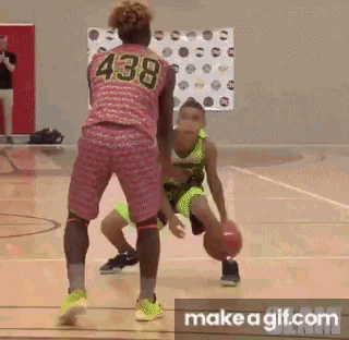 A Girl Is Dribbling A Basketball On A Basketball Court While Another Girl Tries To Stop Her . GIF