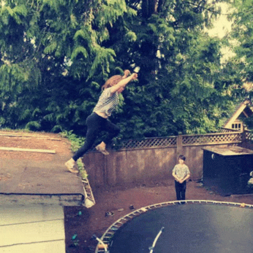A Girl Is Jumping On A Trampoline While A Boy Looks On GIF