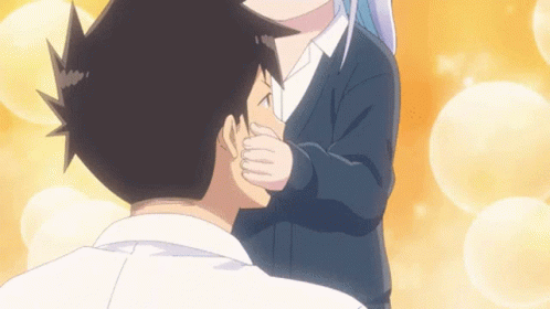 A Girl Is Kissing A Boy On The Cheek GIF