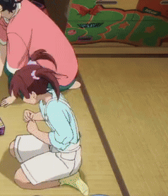 A Girl Is Kneeling Down On The Floor While A Man Sits Behind Her GIF