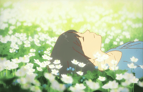 A Girl Is Laying In A Field Of Flowers With Her Eyes Closed GIF