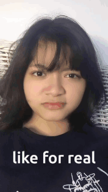 A Girl Is Making A Funny Face While Wearing A Black Shirt That Says Like For Real . GIF
