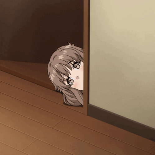 A Girl Is Peeking Out Of A Doorway And Looking At The Camera GIF