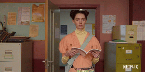 A Girl Is Reading A Book In A Room With A Netflix Logo GIF