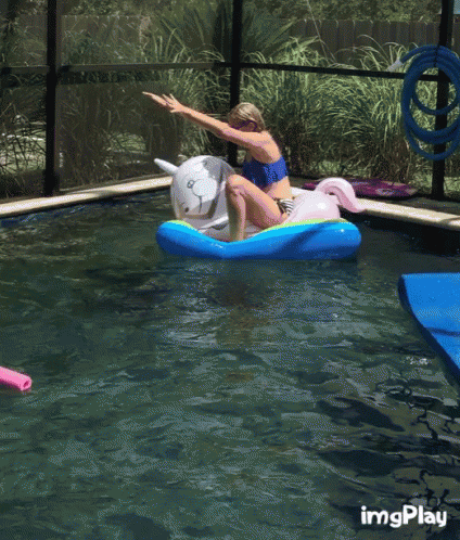 A Girl Is Riding A Unicorn Float In A Pool GIF