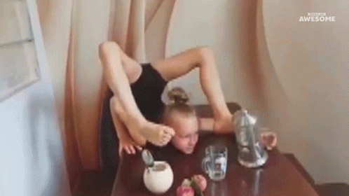 A Girl Is Sitting At A Table With Her Legs Crossed And A Pitcher Of Water . GIF