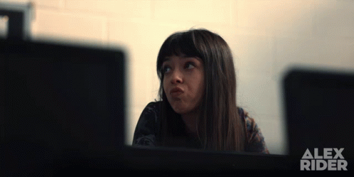 A Girl Is Sitting In Front Of A Computer Screen With Alex Rider Written On It GIF
