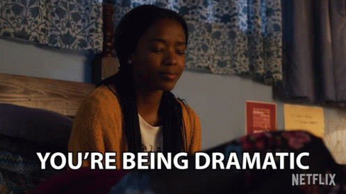 A Girl Is Sitting On A Bed With The Words You 'Re Being Dramatic Above Her GIF