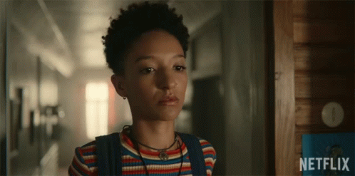 A Girl Is Standing In A Hallway With A Netflix Logo In The Background GIF