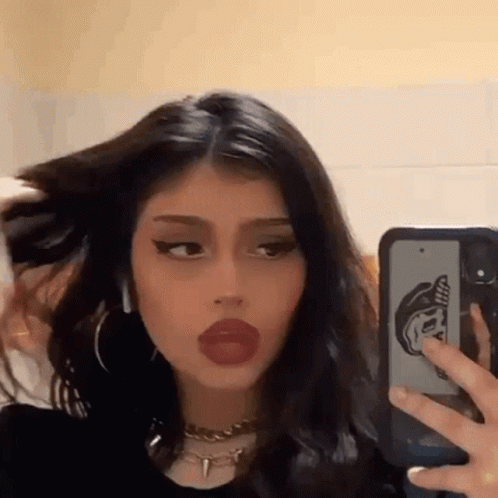 A Girl Is Taking A Picture Of Herself In The Mirror With Her Phone . GIF
