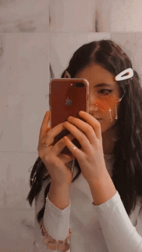 A Girl Is Taking A Picture Of Herself With An Apple Iphone GIF