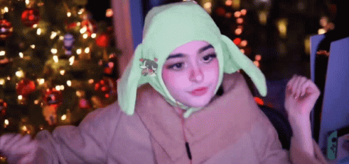 A Girl Is Wearing A Green Hat With Bunny Ears GIF