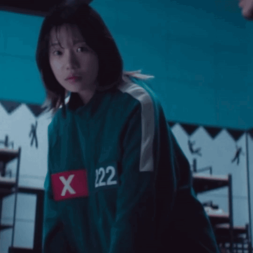 A Girl Is Wearing A Green Jacket With The Number 122 On The Sleeve GIF