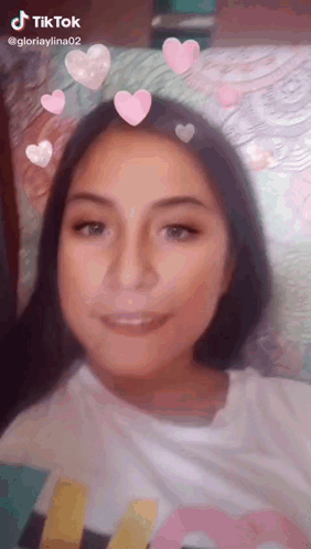 A Girl Is Wearing A Tiktok Filter With Pink Hearts On Her Hair . GIF