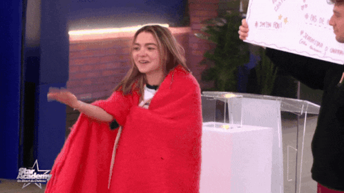 Girl Wrapped In Red Blanket With Star Academy Sign GIF