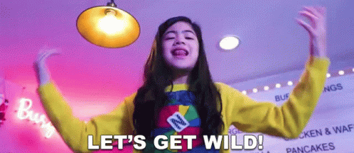 A Girl Says Let 'S Get Wild In Front Of A Sign That Says Pancakes GIF